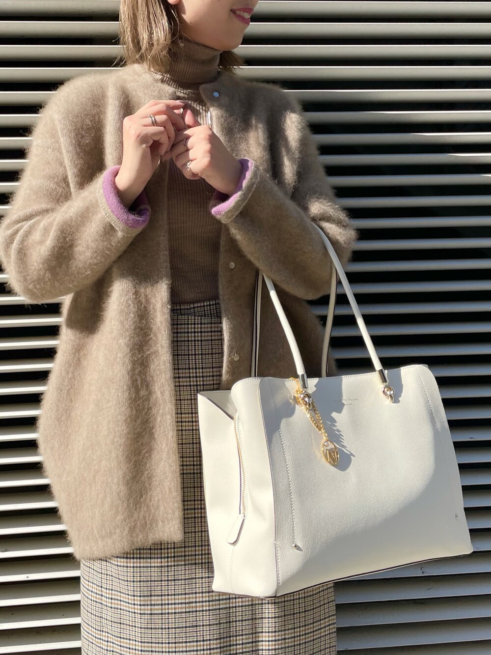ホワイト系のトートバッグ、ベージュ系のカーディガン/ボレロ、ベージュ系のニット/セーターを着用したレディースの冬コーディネートの4枚目の写真