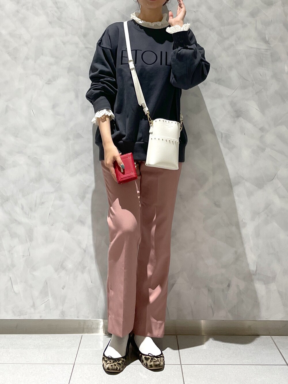 ブラウン系のシューズ、ブラック系のトップス、ホワイト系のショルダーバッグを着用したレディースの冬コーディネートの3枚目の写真