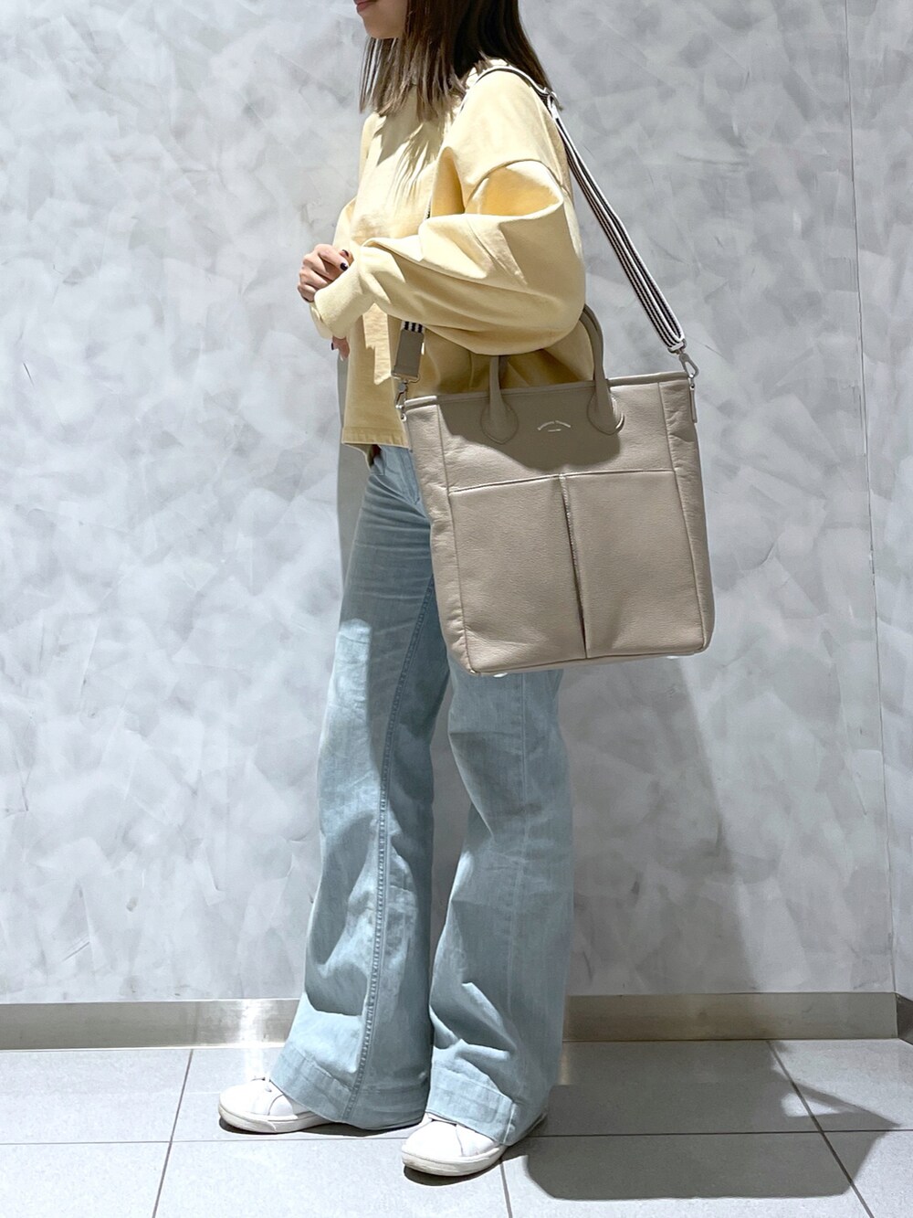 ベージュ系のトートバッグを着用したレディースの冬コーディネートの2枚目の写真