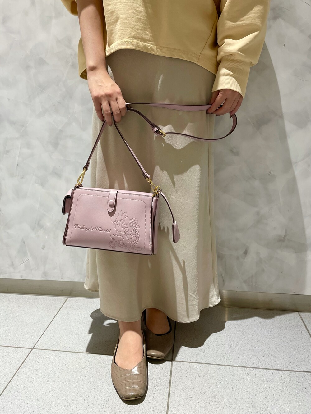 ピンク系のショルダーバッグ、イエロー系のスウェットを着用したレディースの冬コーディネートの5枚目の写真