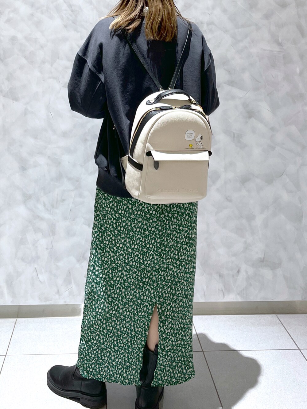 グリーン系のスカート、ホワイト系のバックパック/リュックを着用したレディースの春コーディネートの2枚目の写真