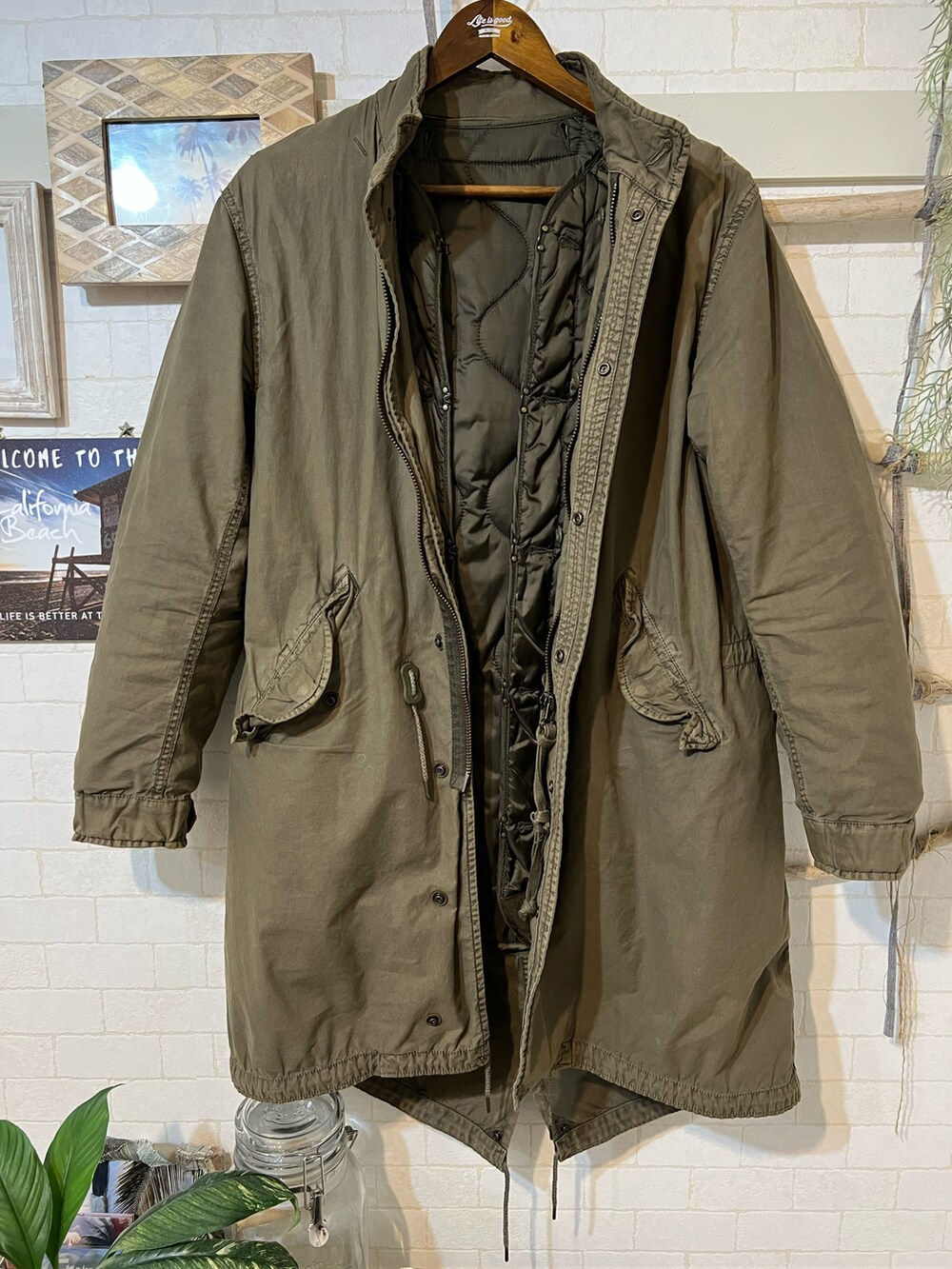 グリーン系のモッズコート、ブラック系のパンツ、ブラック系のブーツを着用したメンズの冬コーディネートの5枚目の写真