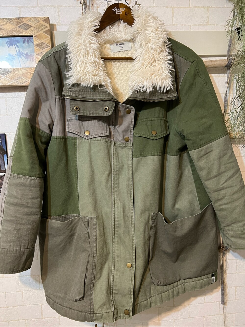 グリーン系のミリタリージャケット、ベージュ系のニット/セーター、ベージュ系のその他パンツを着用したメンズの冬コーディネートの3枚目の写真