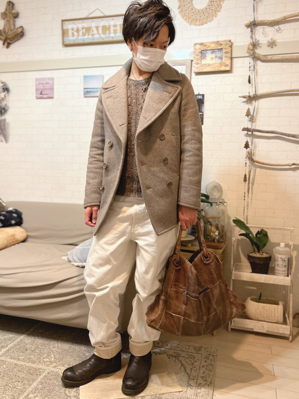 ベージュ系のピーコート、ブラウン系のハンドバッグ、ブラウン系のニット/セーターを着用したメンズの冬コーディネートの3枚目の写真