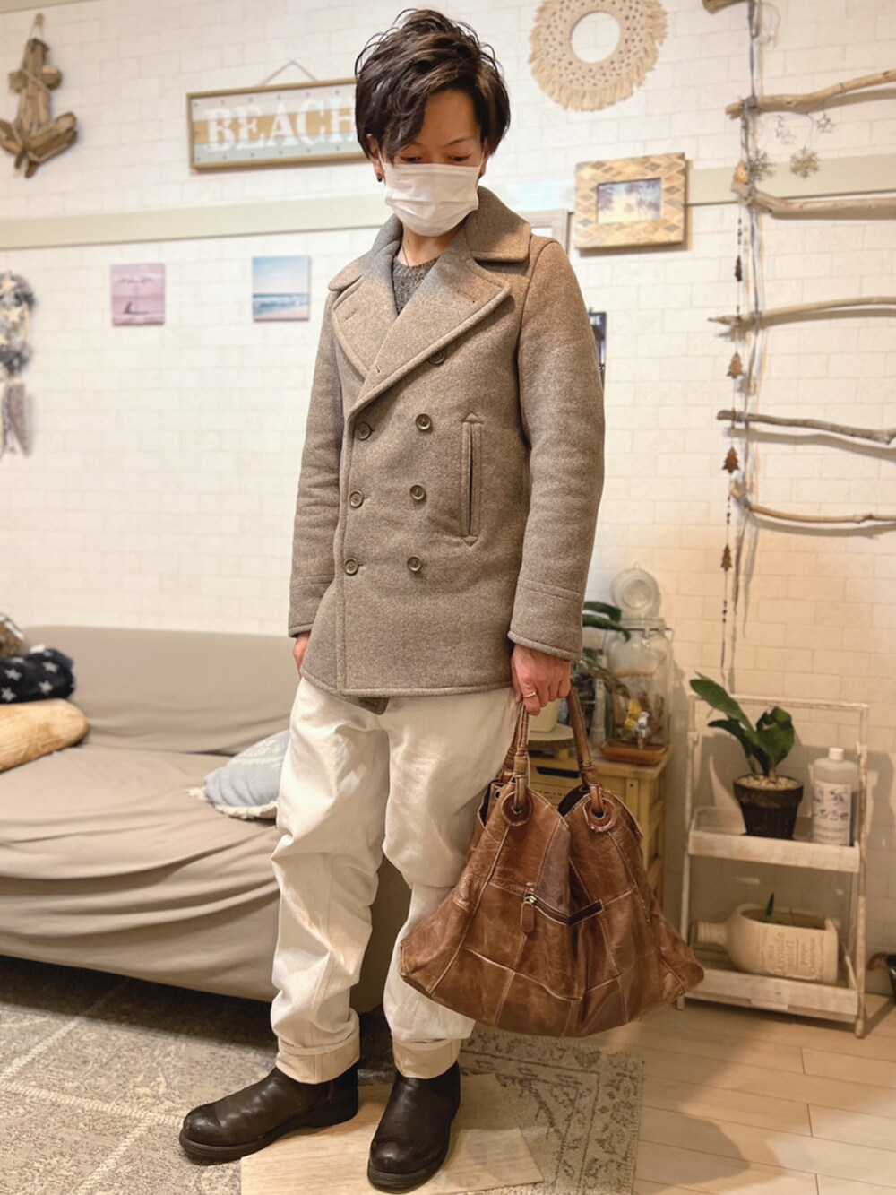 ベージュ系のピーコート、ブラウン系のハンドバッグ、ブラウン系のニット/セーターを着用したメンズの冬コーディネートの2枚目の写真