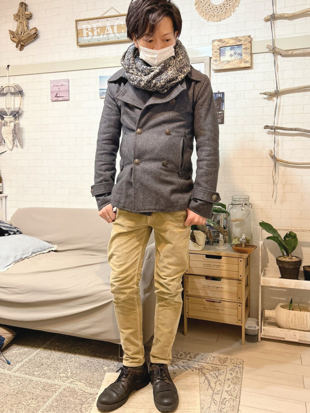 グレー系のピーコート、グレー系のTシャツ/カットソー、グリーン系のニット/セーターを着用したメンズの冬コーディネートの2枚目の写真
