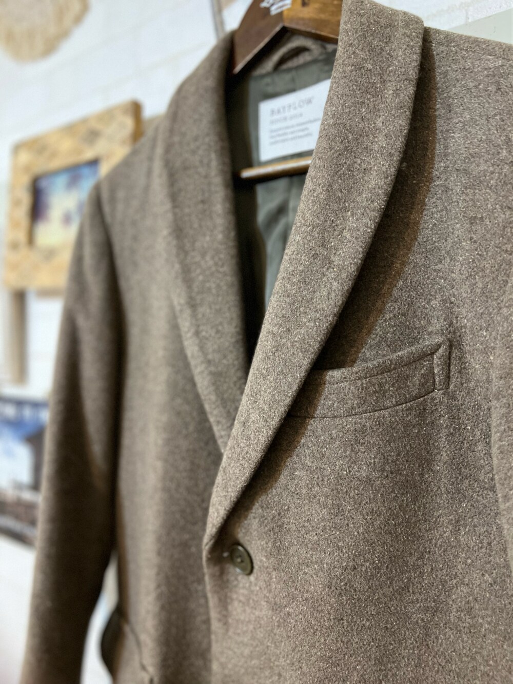 ベージュ系のチェスターコート、グリーン系のニット/セーター、グリーン系のブーツを着用したメンズの冬コーディネートの2枚目の写真