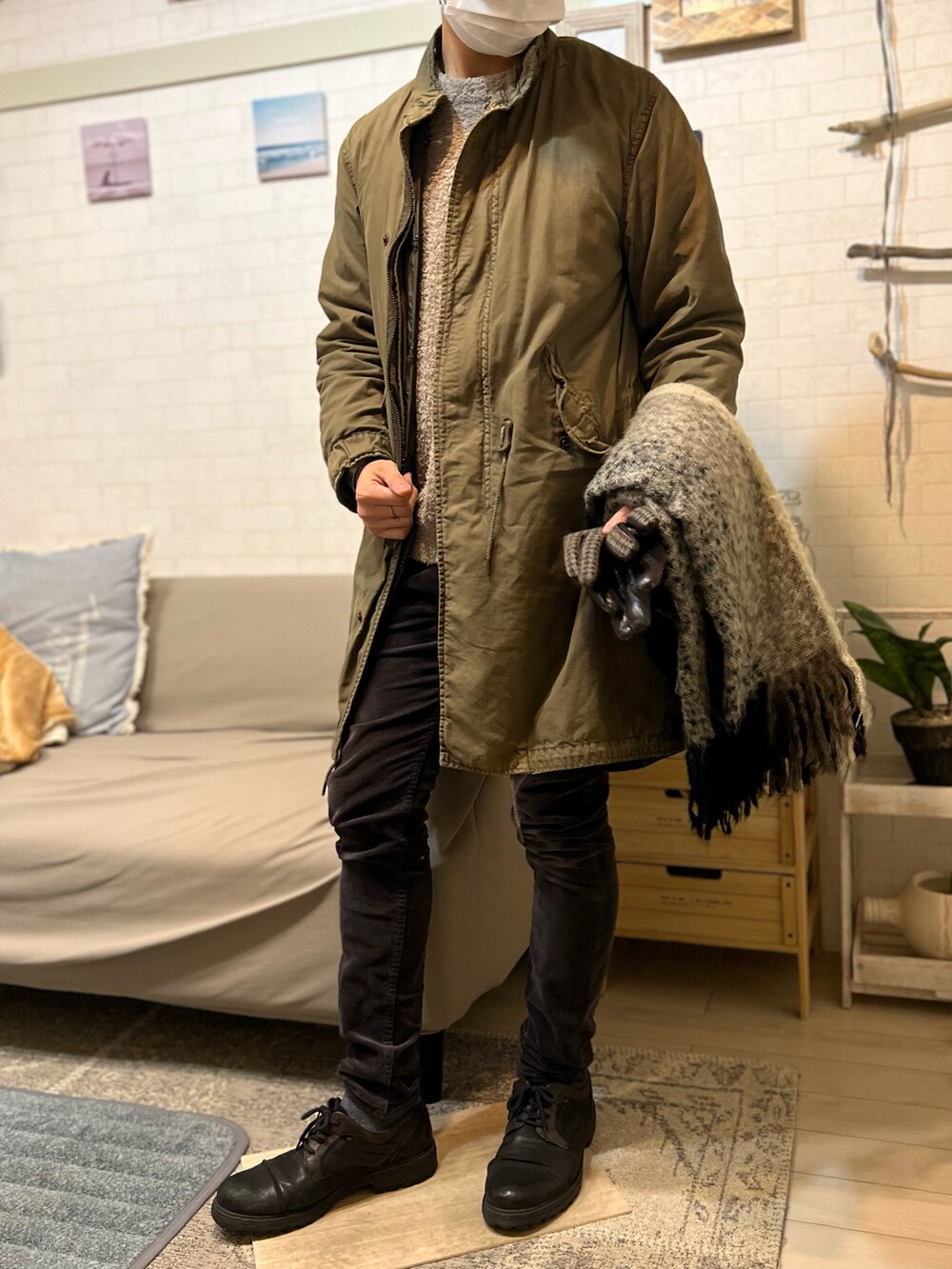 グリーン系のモッズコート、ブラック系のパンツ、ブラック系のブーツを着用したメンズの冬コーディネートの2枚目の写真