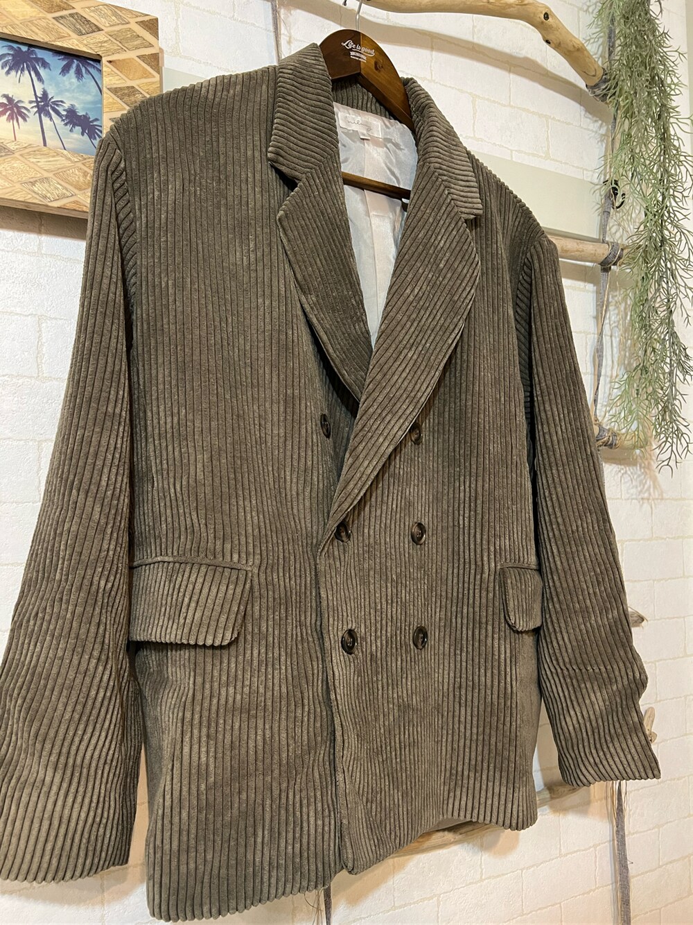 ブラウン系のテーラードジャケット、グリーン系のスウェット、ブラック系のパンツを着用したメンズの冬コーディネートの2枚目の写真