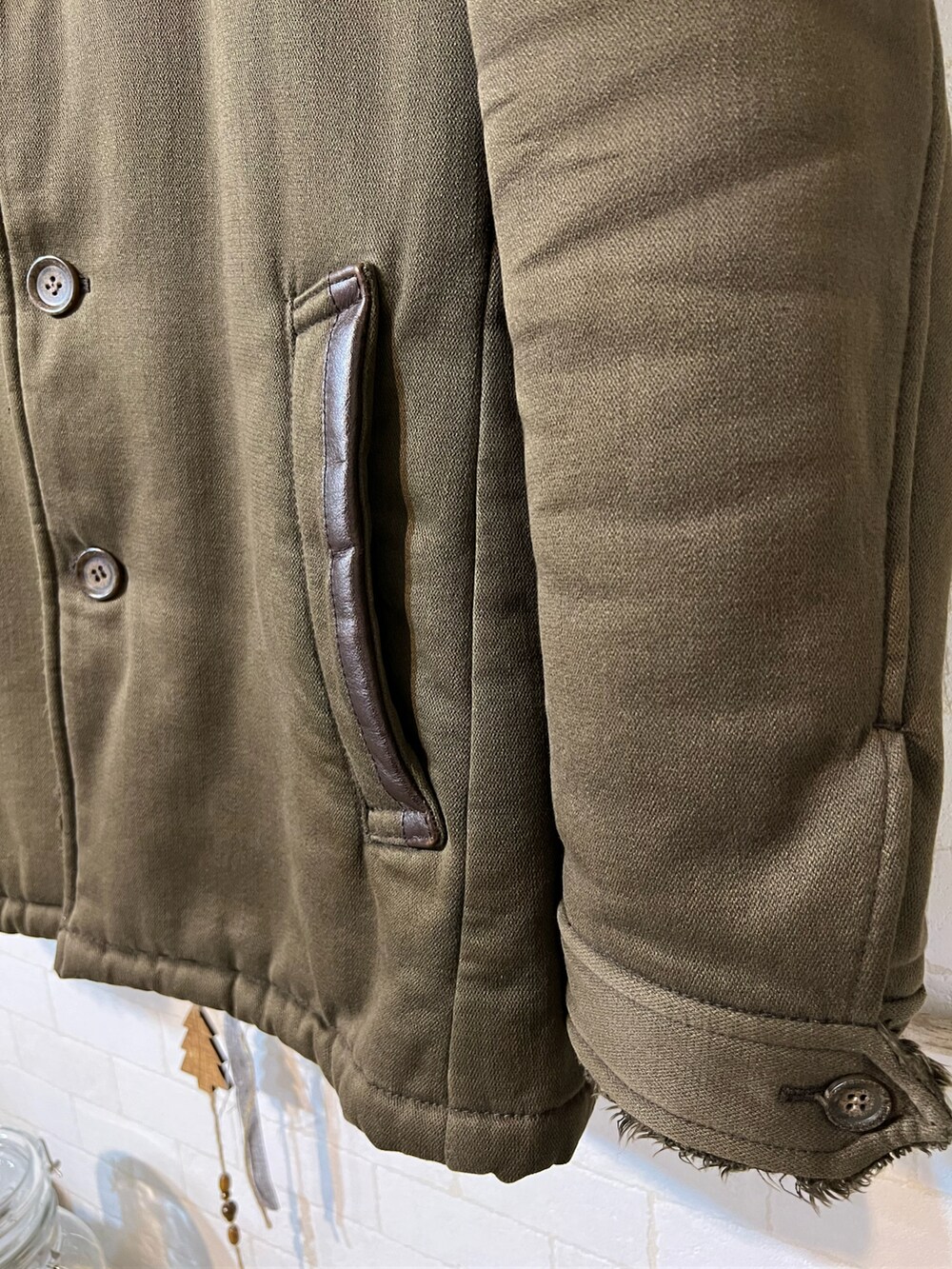 グリーン系のジャケット/アウター、ベージュ系のニット/セーター、ベージュ系のその他パンツを着用したメンズの冬コーディネートの5枚目の写真