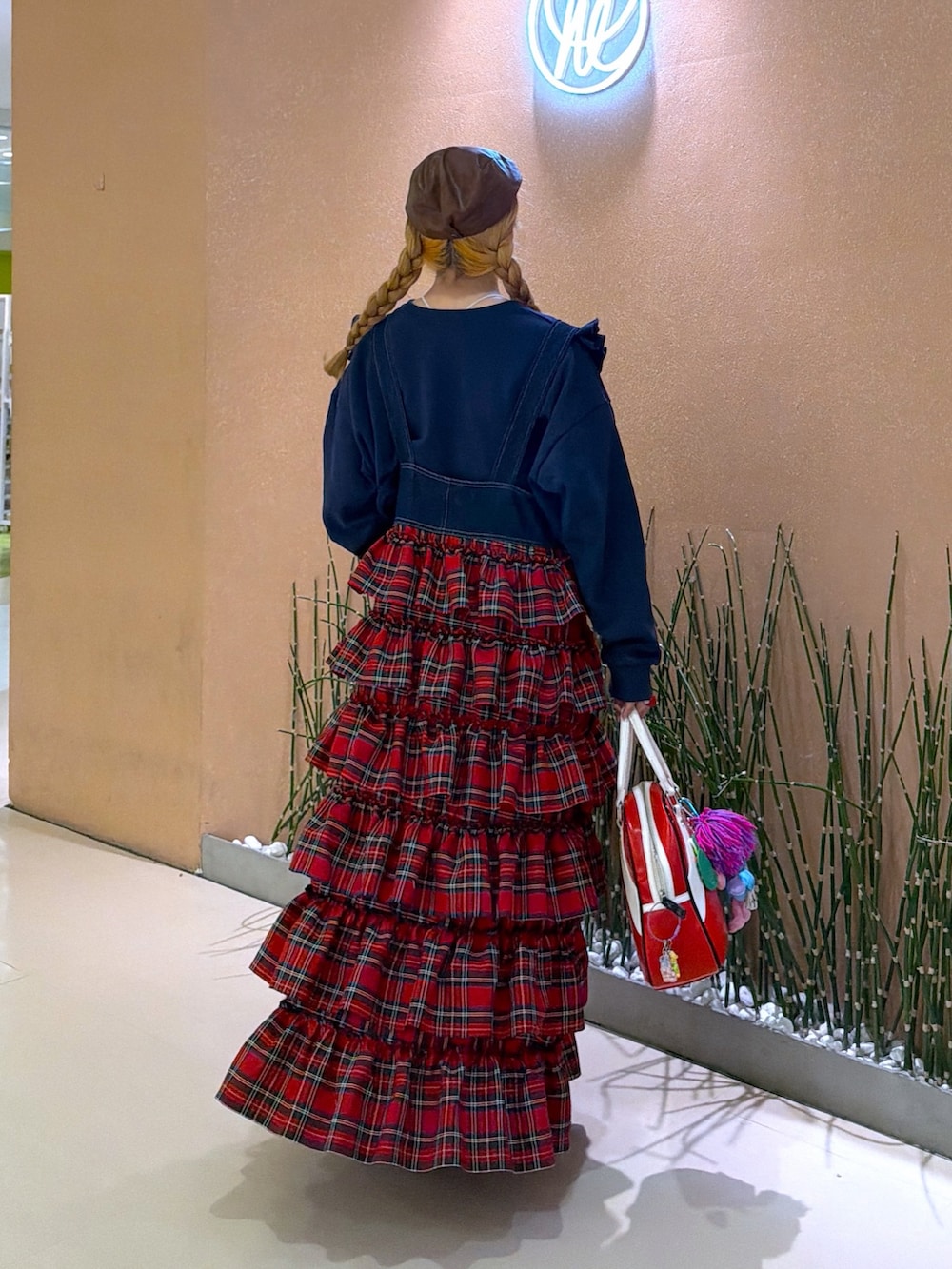 レッド系のジャンパースカート、ブルー系のTシャツ/カットソーを着用したレディースの冬コーディネートの4枚目の写真