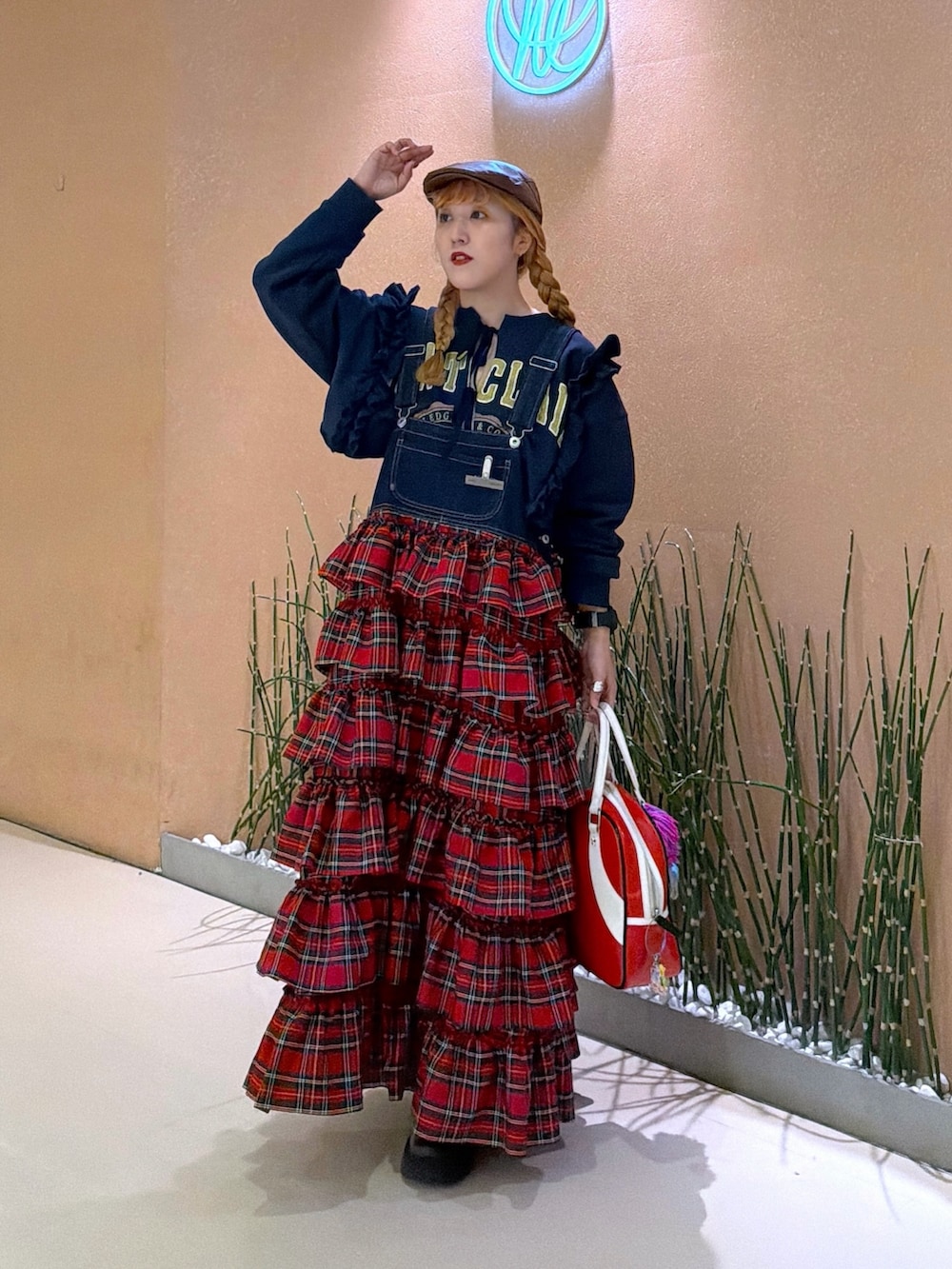 レッド系のジャンパースカート、ブルー系のTシャツ/カットソーを着用したレディースの冬コーディネートの3枚目の写真