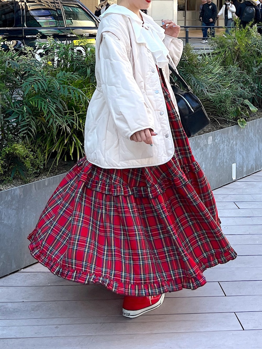 レッド系のワンピース、ホワイト系のその他アウター、ホワイト系のシャツ/ブラウスを着用したレディースの冬コーディネートの2枚目の写真