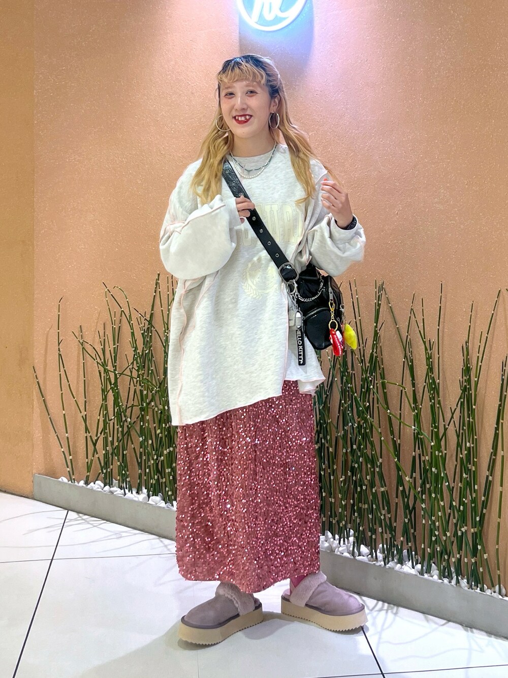 ピンク系のスカート、グレー系のTシャツ/カットソー、パープル系のブーツを着用したレディースの秋コーディネートの2枚目の写真