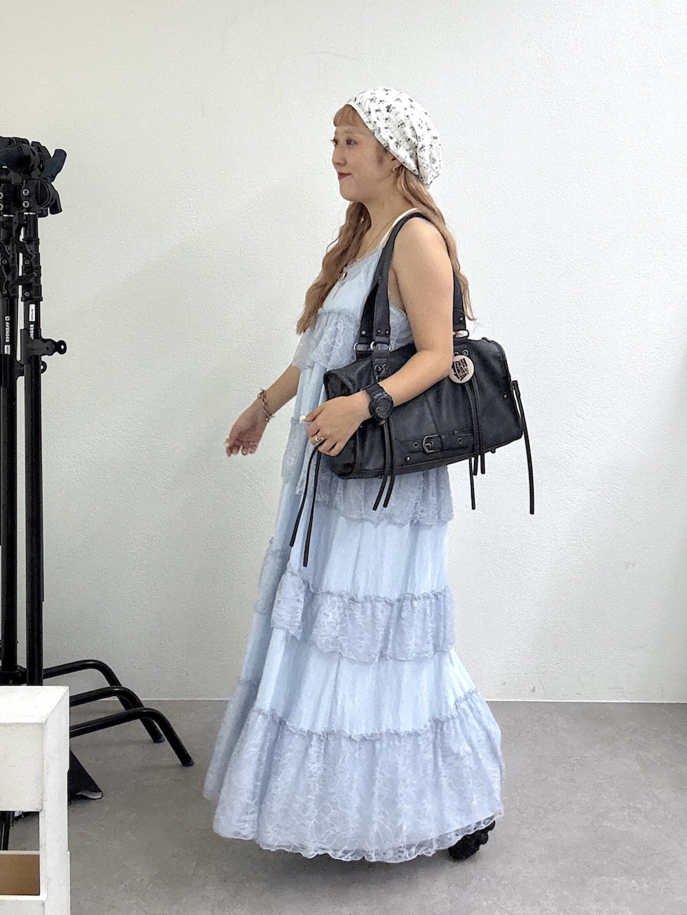 ブルー系のワンピース、ブラック系のボストンバッグ、ブラック系のスニーカーを着用したレディースの夏コーディネートの2枚目の写真