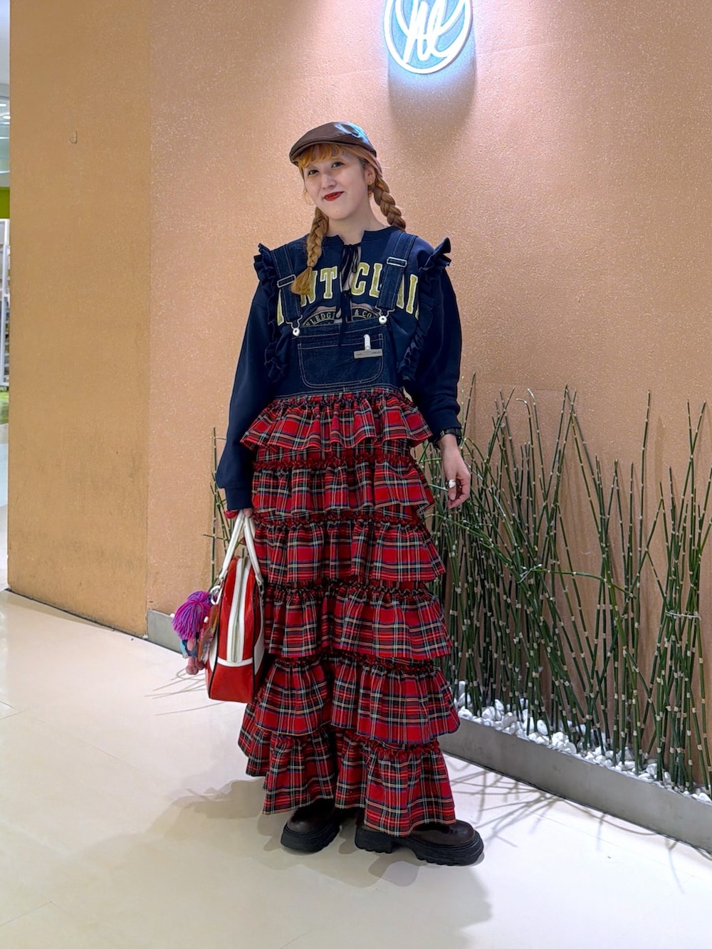 レッド系のジャンパースカート、ブルー系のTシャツ/カットソーを着用したレディースの冬コーディネートの2枚目の写真