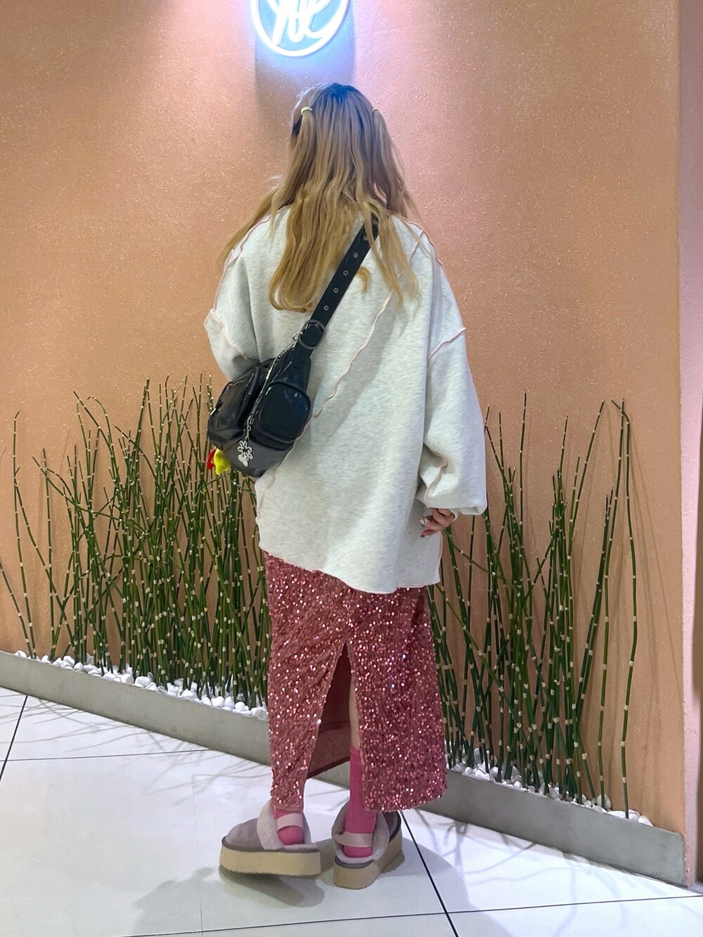 ピンク系のスカート、グレー系のTシャツ/カットソー、パープル系のブーツを着用したレディースの秋コーディネートの3枚目の写真