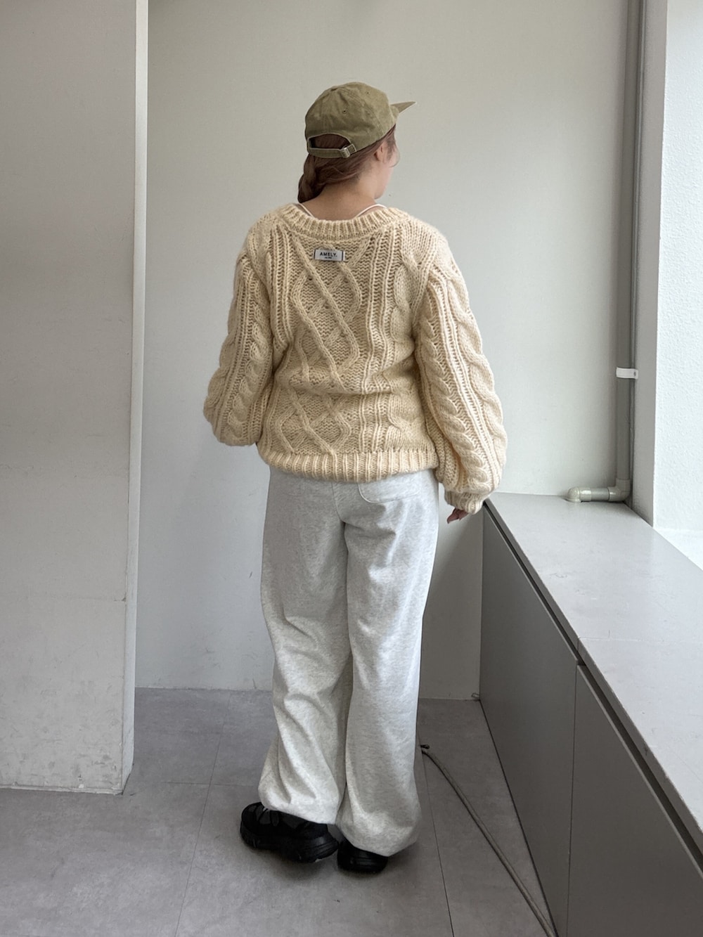 ホワイト系のニット/セーター、ホワイト系のその他パンツ、グレー系のスニーカーを着用したレディースの夏コーディネートの4枚目の写真