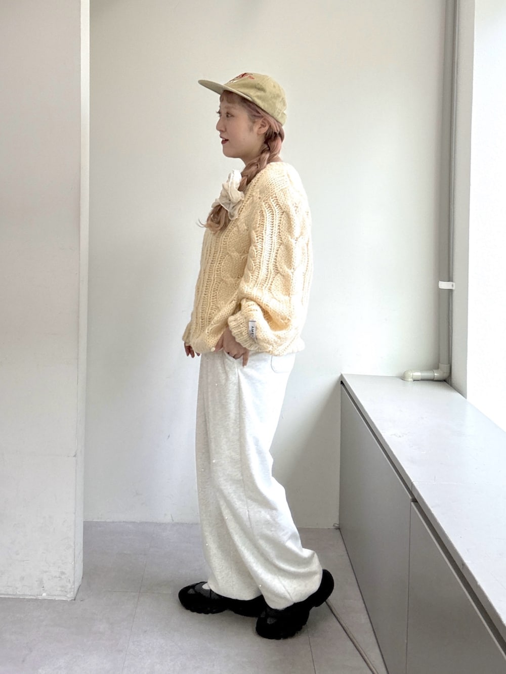 ホワイト系のニット/セーター、ホワイト系のその他パンツ、グレー系のスニーカーを着用したレディースの夏コーディネートの3枚目の写真