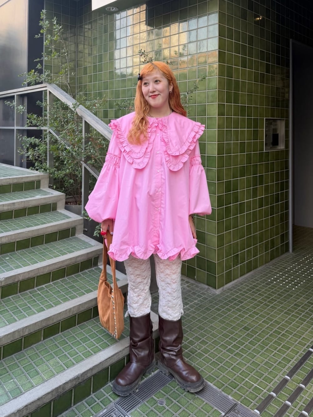 ピンク系のワンピース、ブラウン系のブーツを着用したレディースの冬コーディネートの6枚目の写真