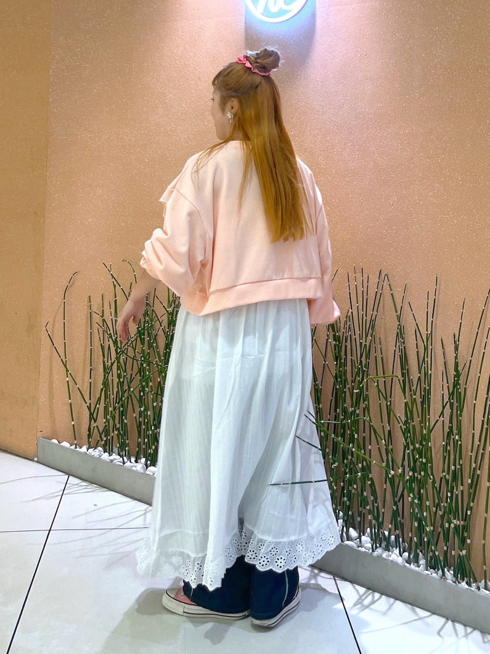 ピンク系のTシャツ/カットソー、ホワイト系のワンピース、ブルー系のデニムパンツを着用したレディースの春コーディネートの2枚目の写真