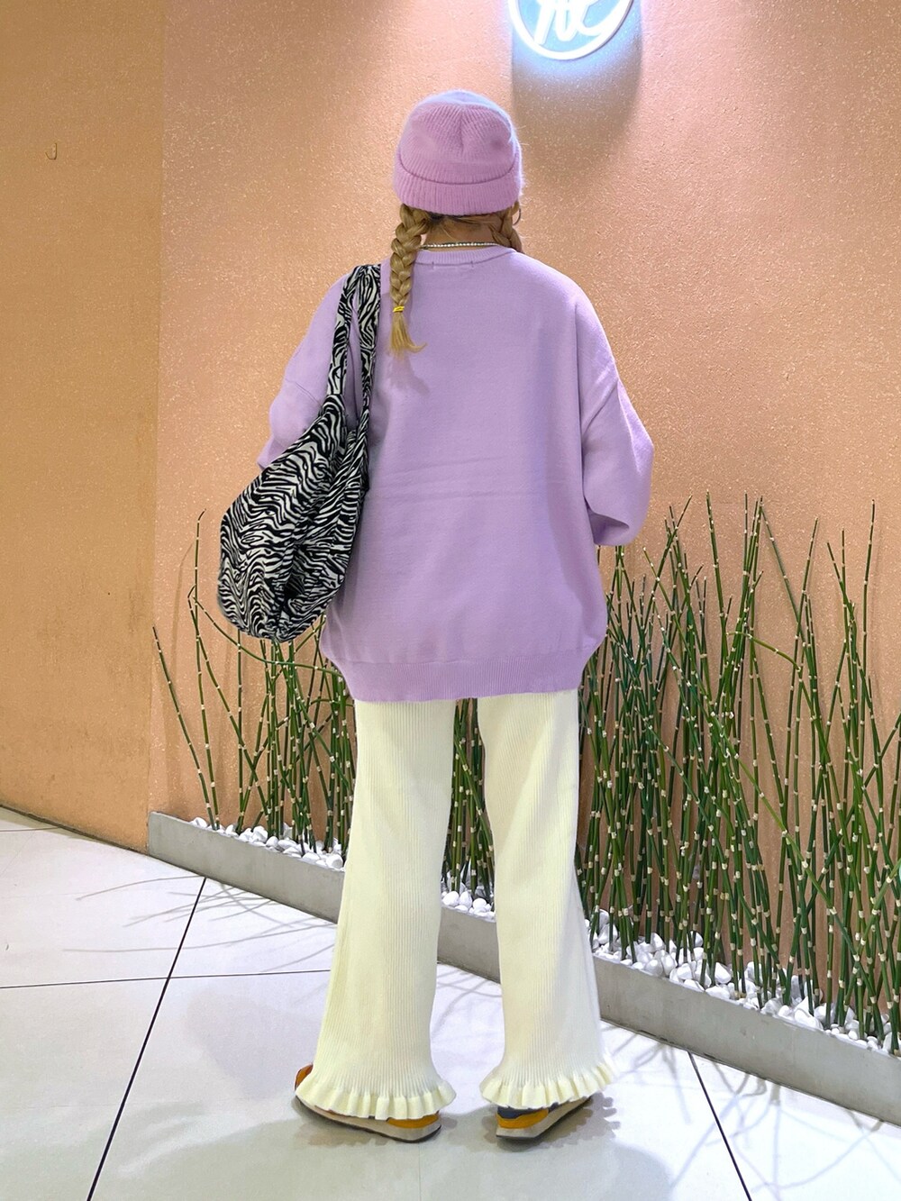 パープル系のニット/セーター、ホワイト系のその他パンツ、パープル系のキャップを着用したレディースの秋コーディネートの3枚目の写真