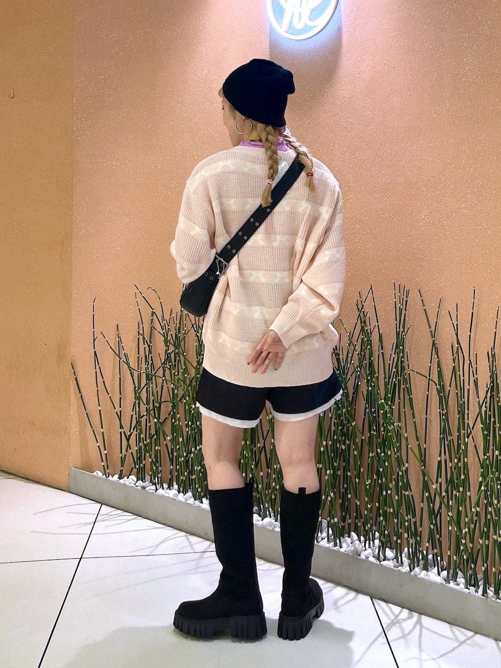 ピンク系のカーディガン/ボレロ、ブラック系のショルダーバッグ、ブラック系のブーツを着用したレディースの秋コーディネートの2枚目の写真