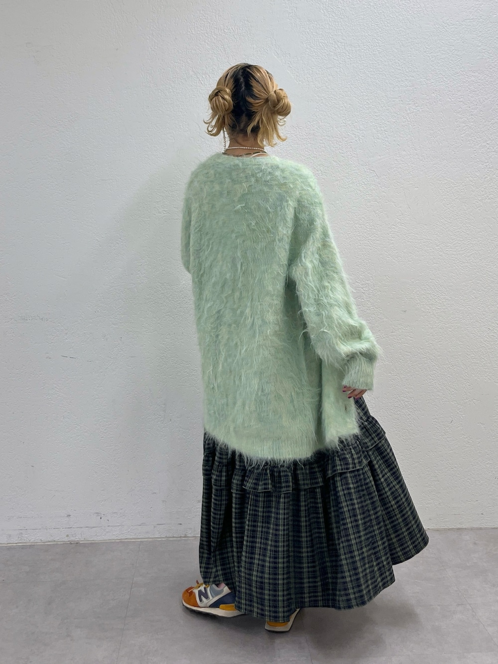 グリーン系のワンピース、ブルー系のカーディガン/ボレロ、オレンジ系のスニーカーを着用したレディースの秋コーディネートの3枚目の写真