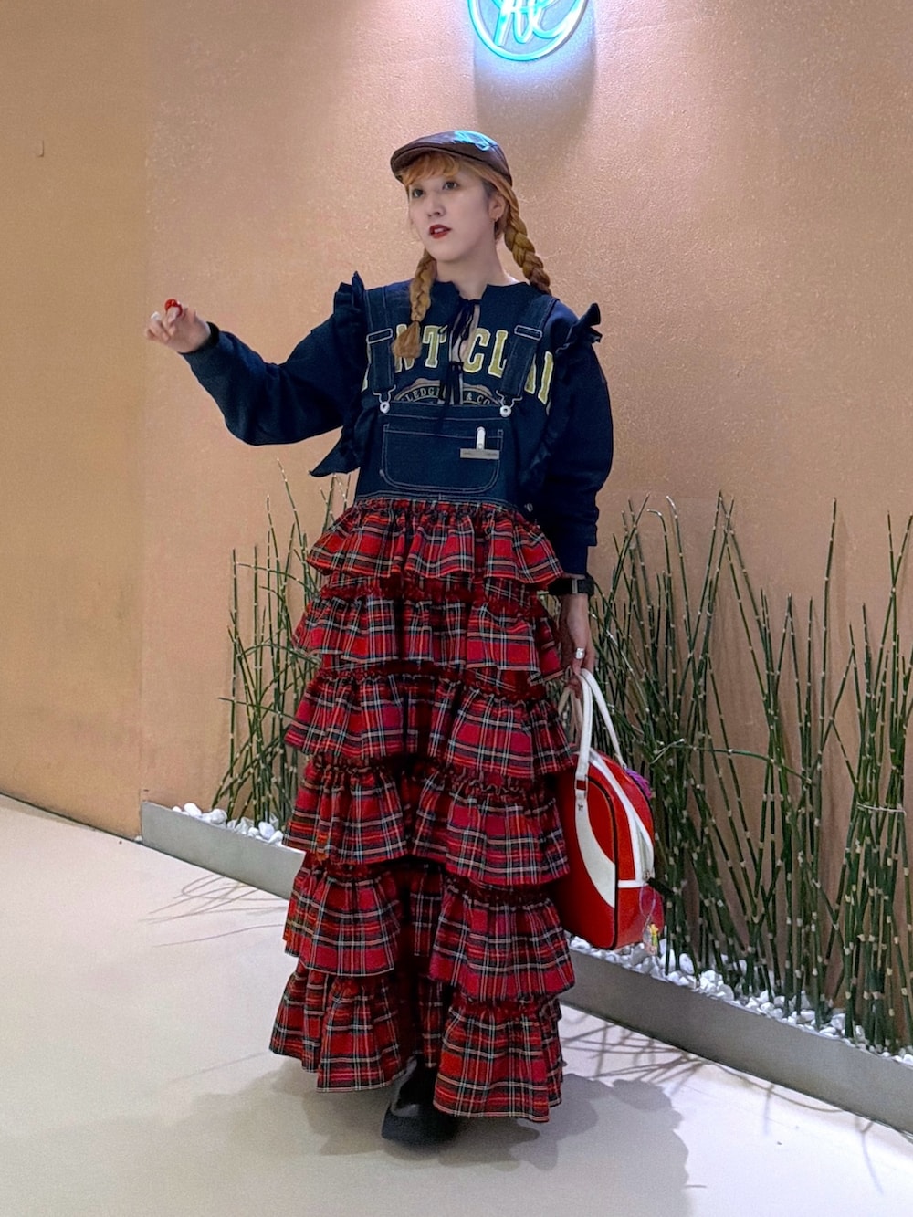 レッド系のジャンパースカート、ブルー系のTシャツ/カットソーを着用したレディースの冬コーディネートの5枚目の写真