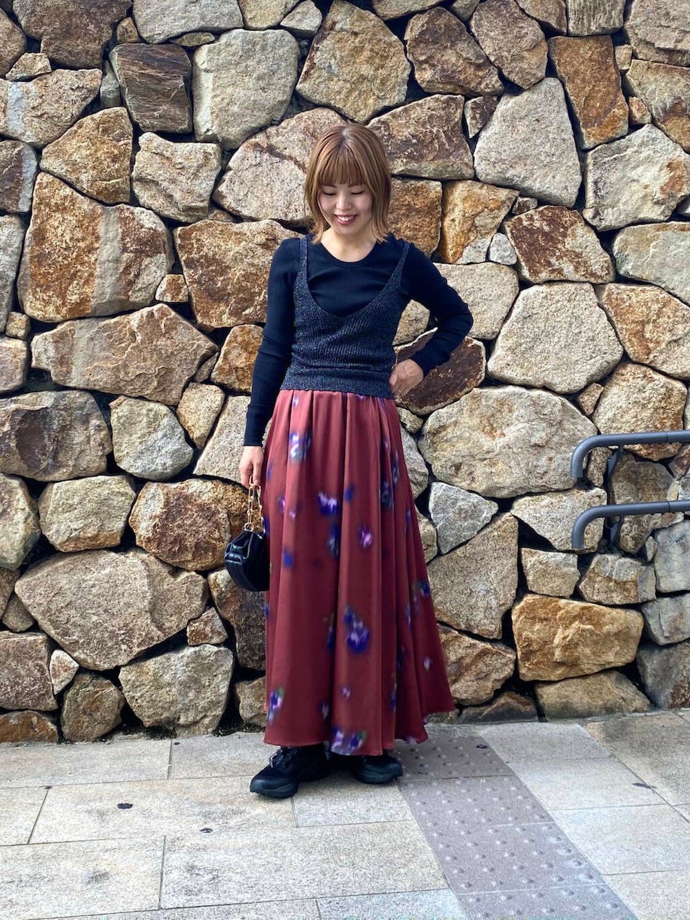 ブラック系のハンドバッグ、ブラック系のキャミソール、ブラック系のTシャツ/カットソーを着用したレディースの秋コーディネートの2枚目の写真