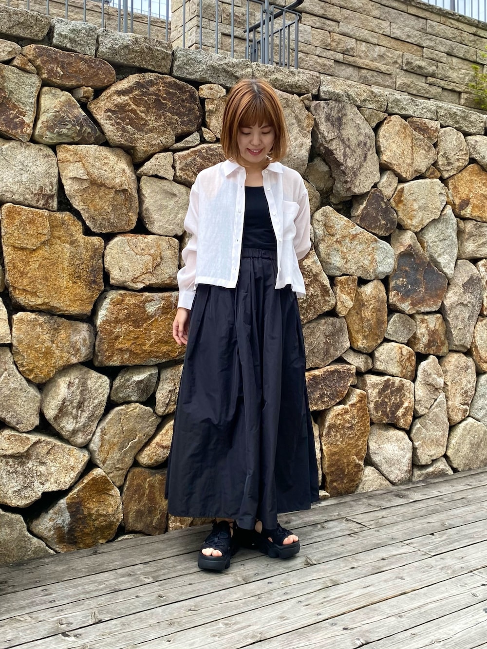 ブラック系のスカート、ベージュ系のシャツ/ブラウス、ブラック系のキャミソールを着用したレディースの春コーディネートの2枚目の写真