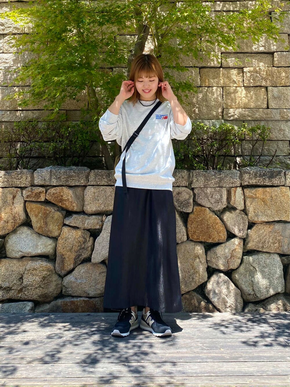 ブラック系のスカート、グレー系のスウェット、ブラック系のスニーカーを着用したレディースの夏コーディネートの5枚目の写真