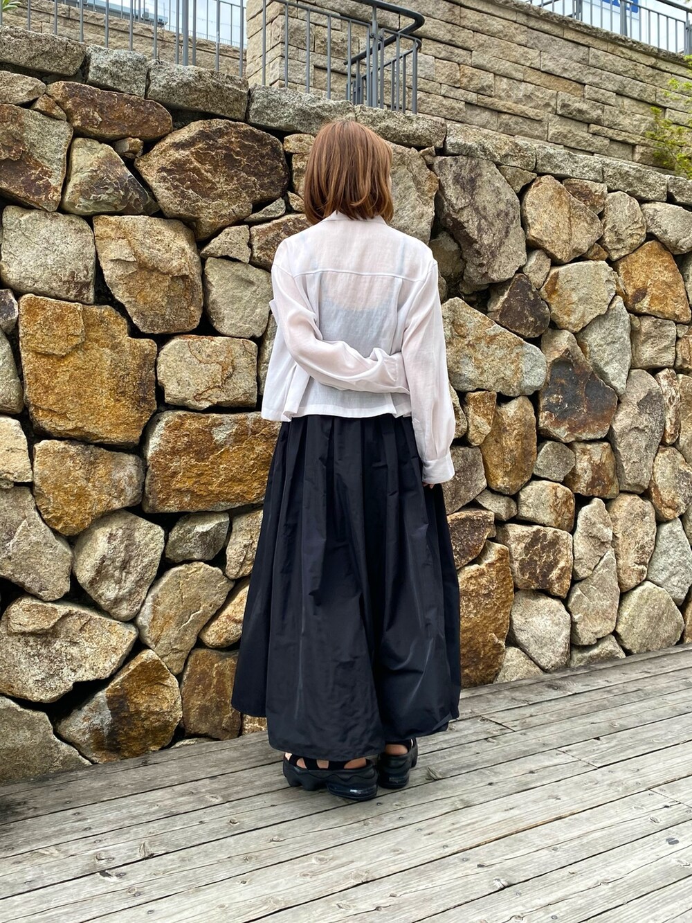 ブラック系のスカート、ベージュ系のシャツ/ブラウス、ブラック系のキャミソールを着用したレディースの春コーディネートの4枚目の写真