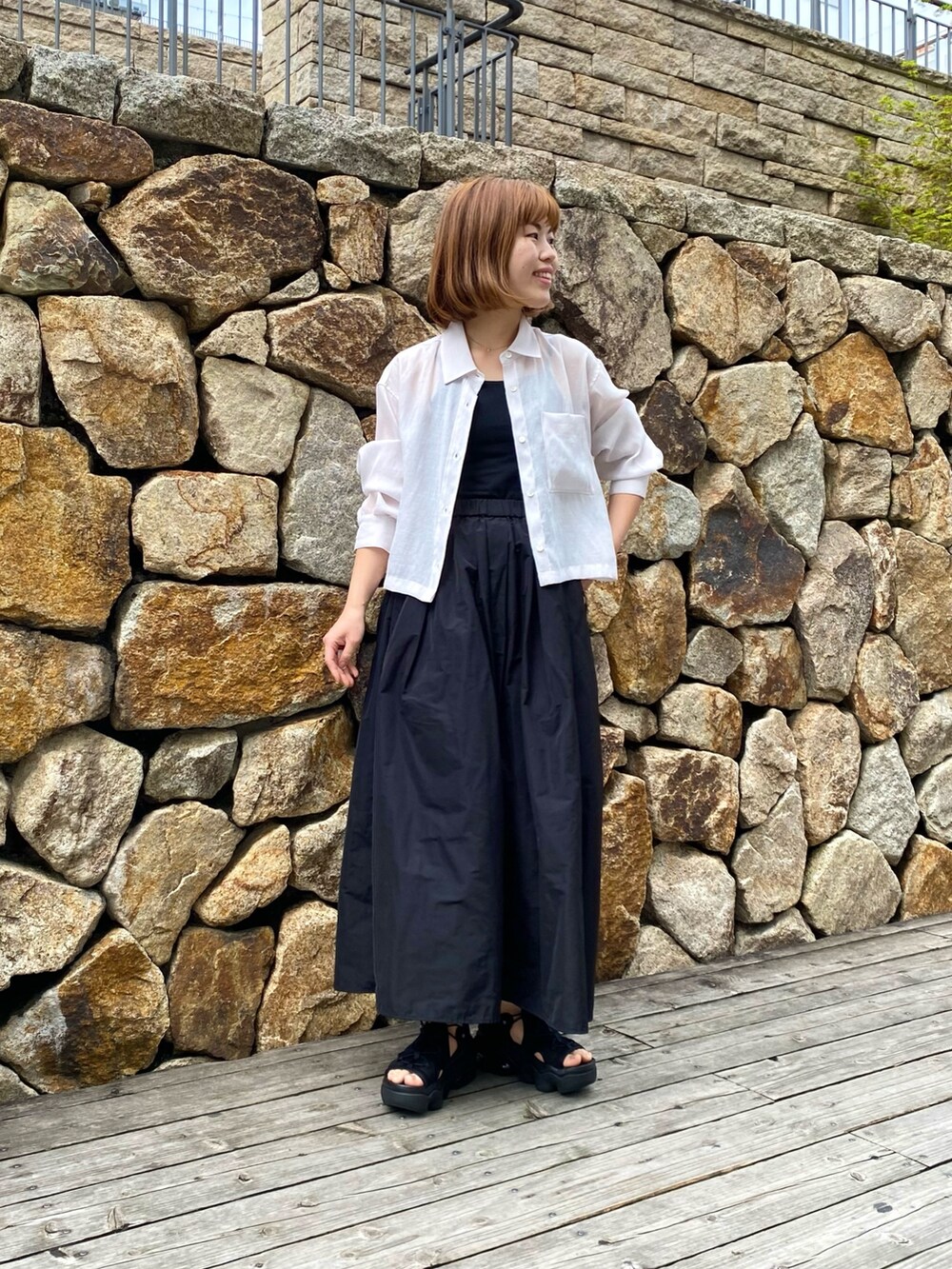 ブラック系のスカート、ベージュ系のシャツ/ブラウス、ブラック系のキャミソールを着用したレディースの春コーディネートの6枚目の写真