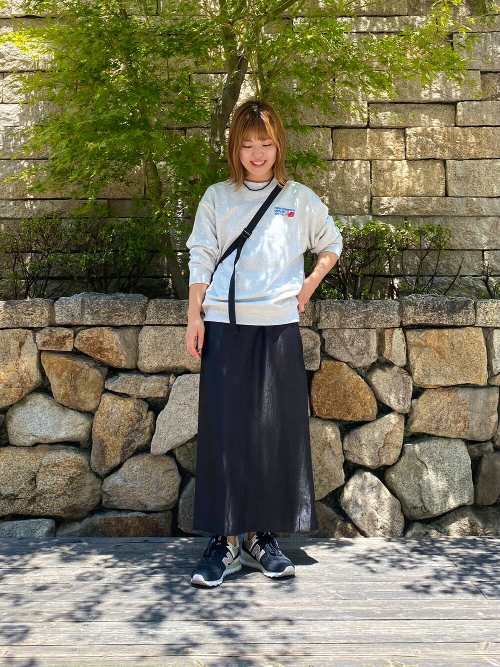 ブラック系のスカート、グレー系のスウェット、ブラック系のスニーカーを着用したレディースの夏コーディネートの2枚目の写真