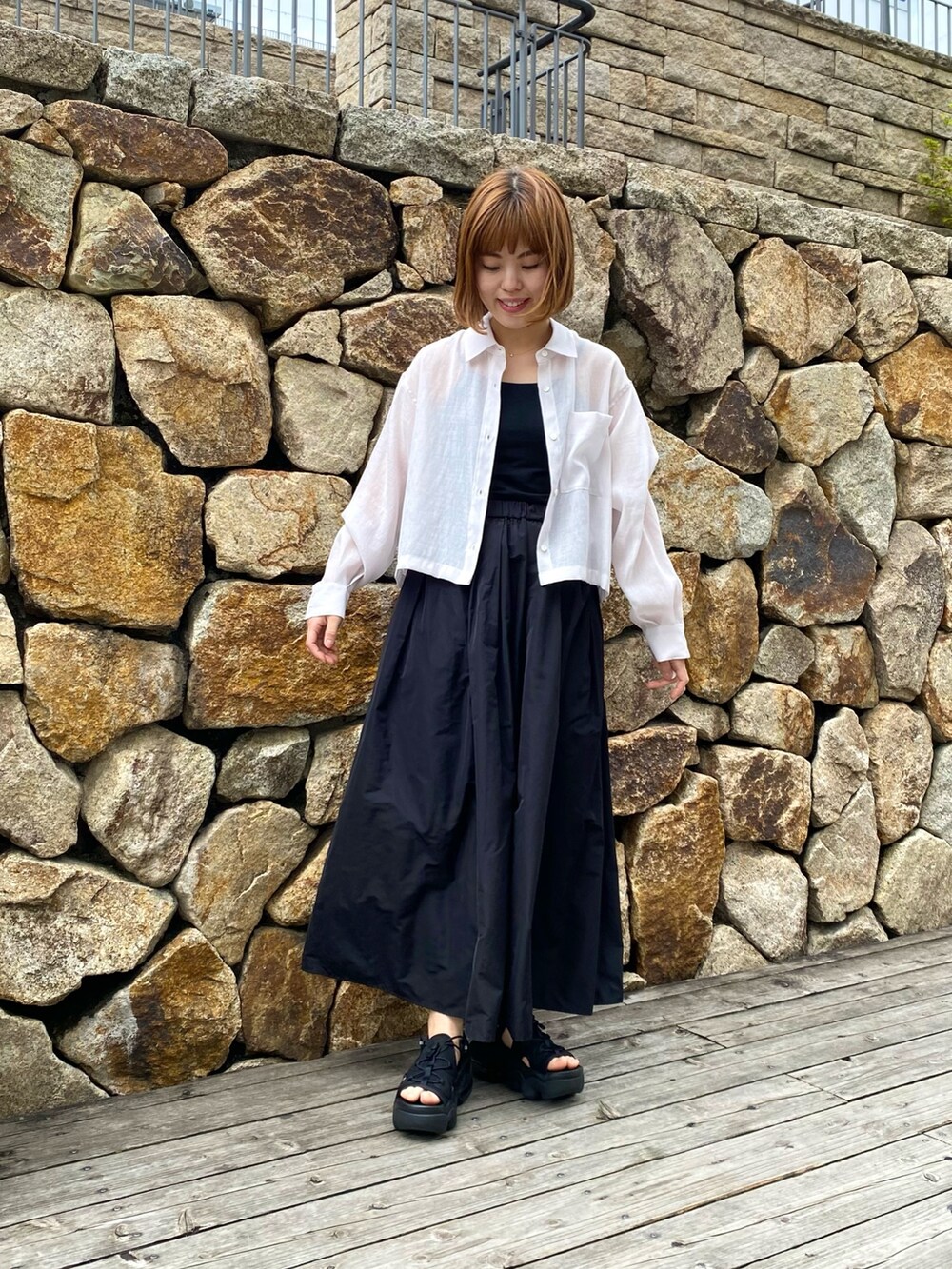 ブラック系のスカート、ベージュ系のシャツ/ブラウス、ブラック系のキャミソールを着用したレディースの春コーディネートの5枚目の写真