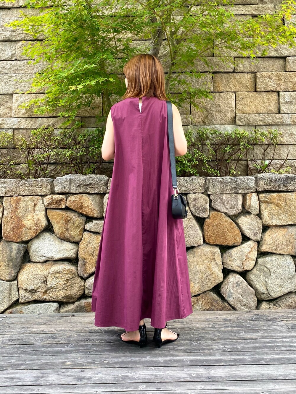 ブラック系のショルダーバッグ、ブラック系のサンダル、レッド系のワンピースを着用したレディースの夏コーディネートの5枚目の写真