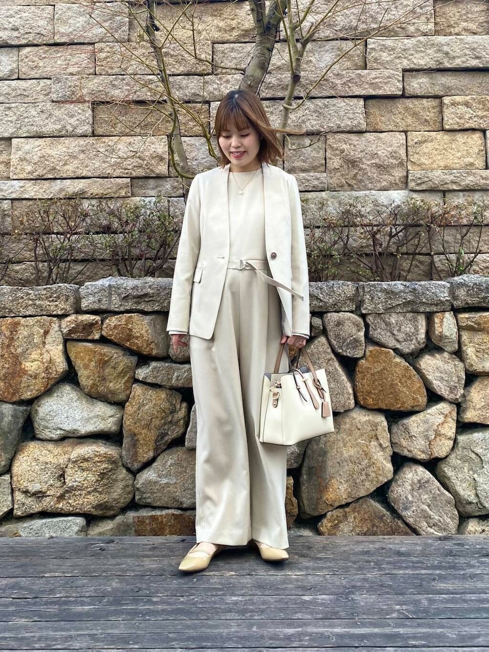 ホワイト系のトートバッグ、ベージュ系のサロペット/オーバーオール、ベージュ系のノーカラージャケットを着用したレディースの春コーディネートの4枚目の写真