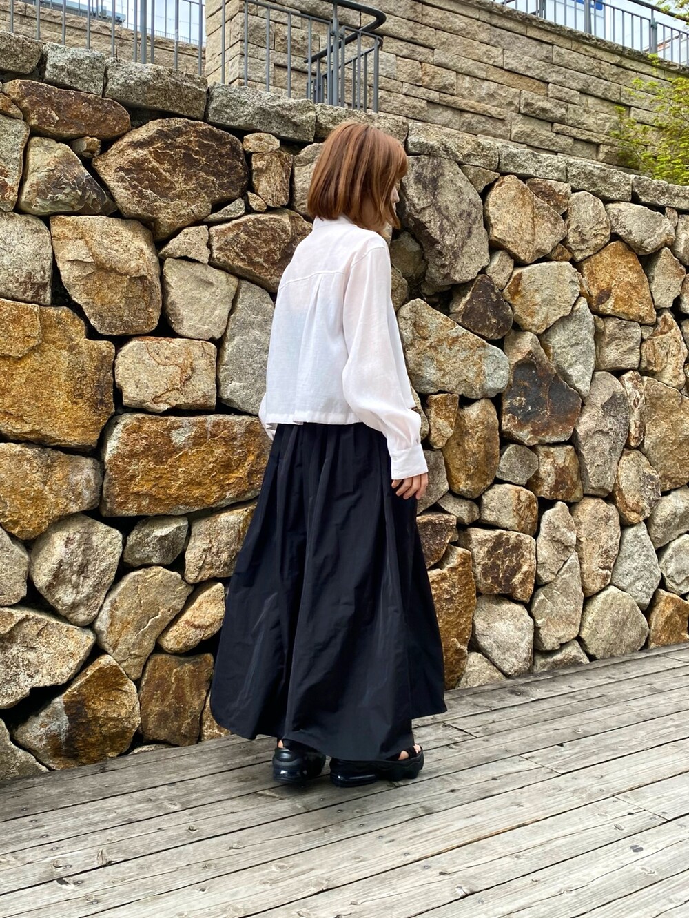 ブラック系のスカート、ベージュ系のシャツ/ブラウス、ブラック系のキャミソールを着用したレディースの春コーディネートの3枚目の写真