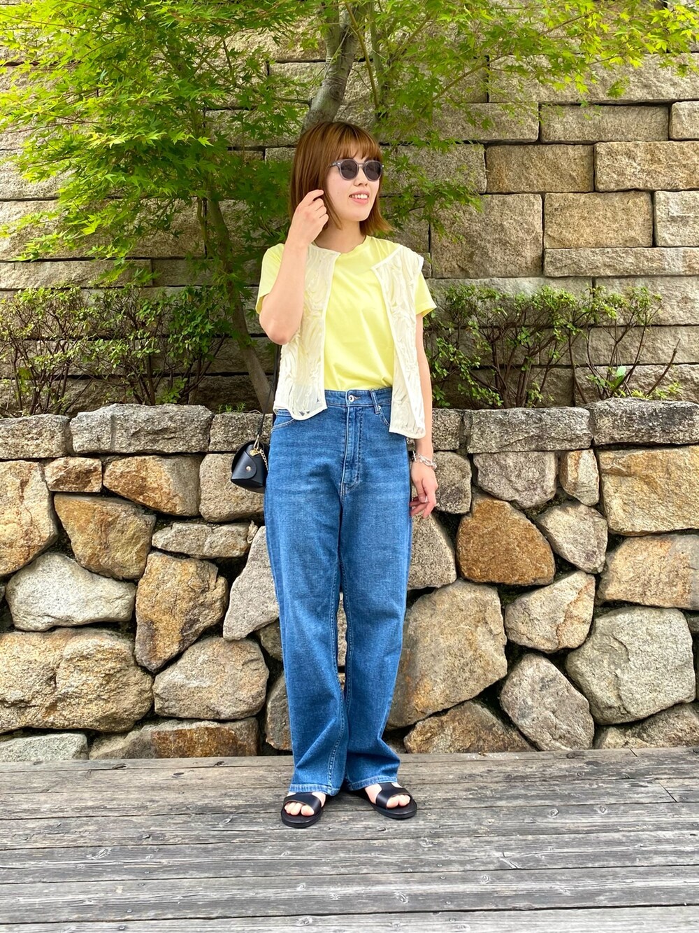 ブラック系のサンダル、ブラック系のショルダーバッグ、ホワイト系のシャツ/ブラウスを着用したレディースの夏コーディネートの6枚目の写真