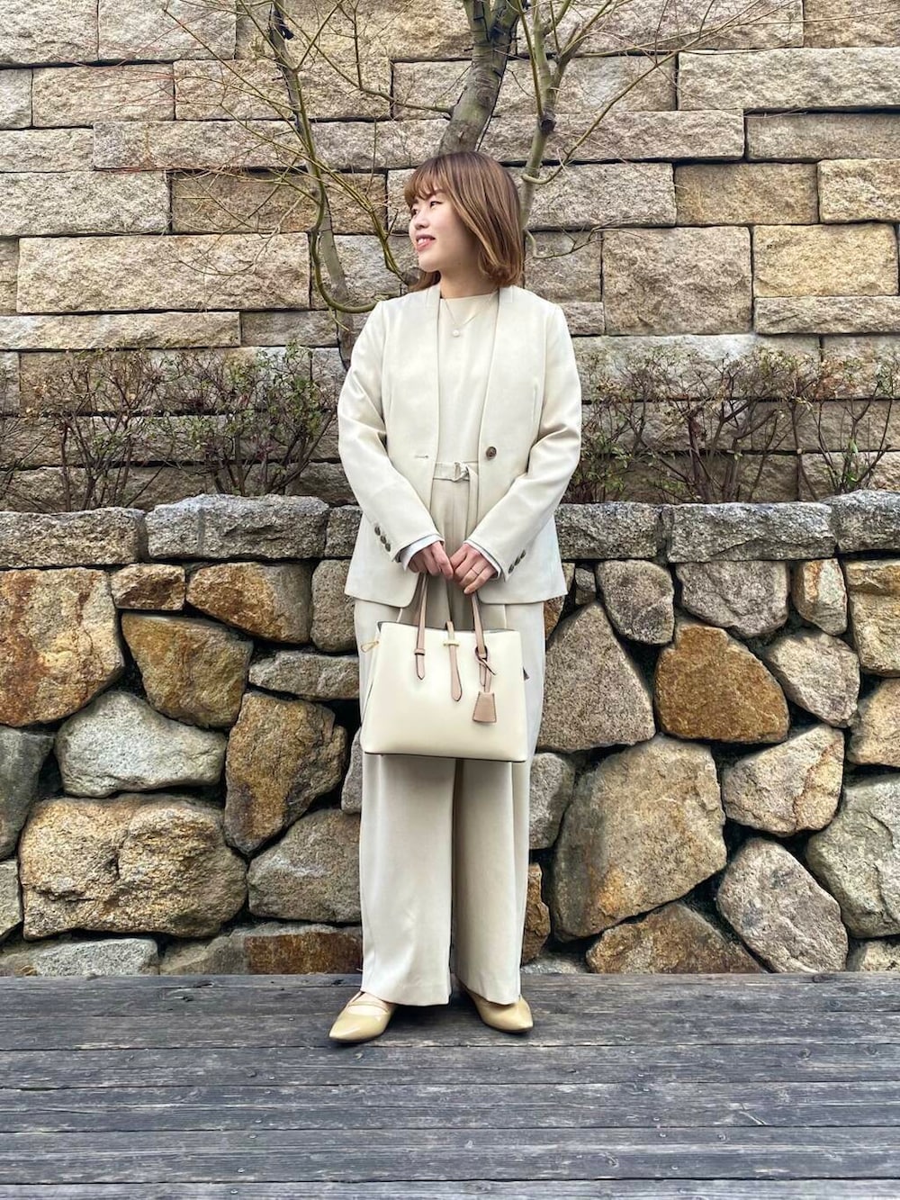 ホワイト系のトートバッグ、ベージュ系のサロペット/オーバーオール、ベージュ系のノーカラージャケットを着用したレディースの春コーディネートの7枚目の写真