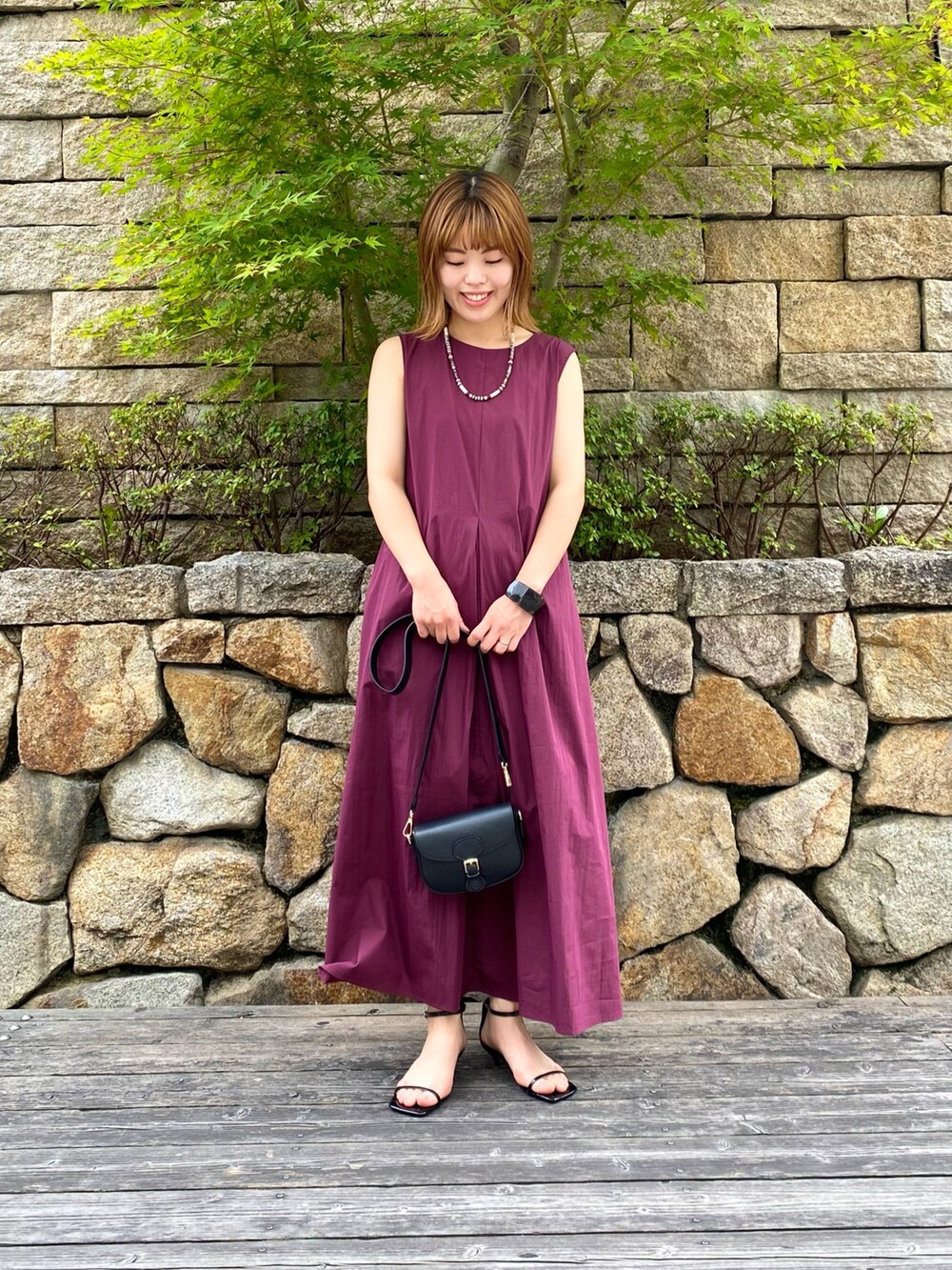 ブラック系のショルダーバッグ、ブラック系のサンダル、レッド系のワンピースを着用したレディースの夏コーディネートの6枚目の写真