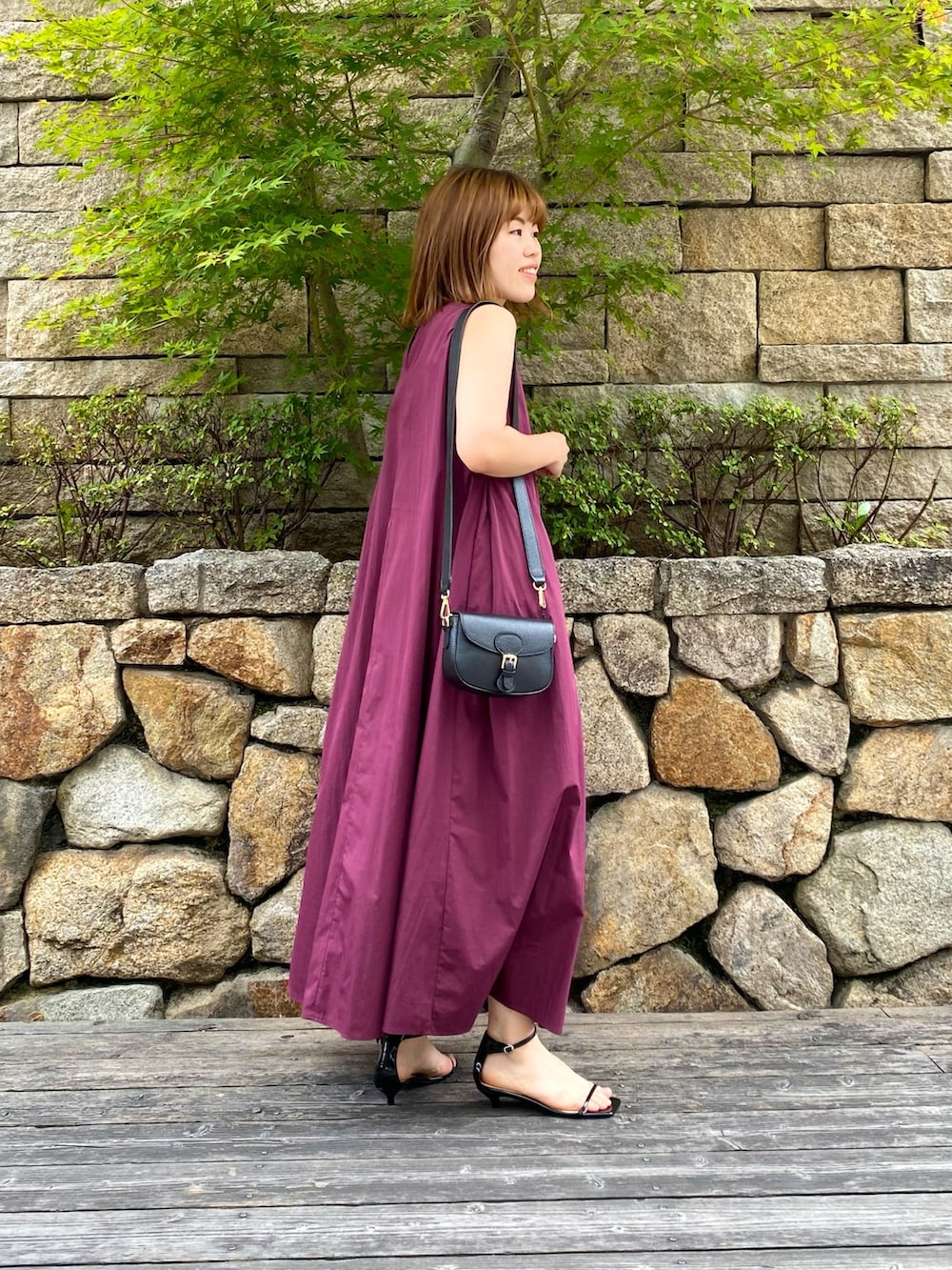 ブラック系のショルダーバッグ、ブラック系のサンダル、レッド系のワンピースを着用したレディースの夏コーディネートの4枚目の写真