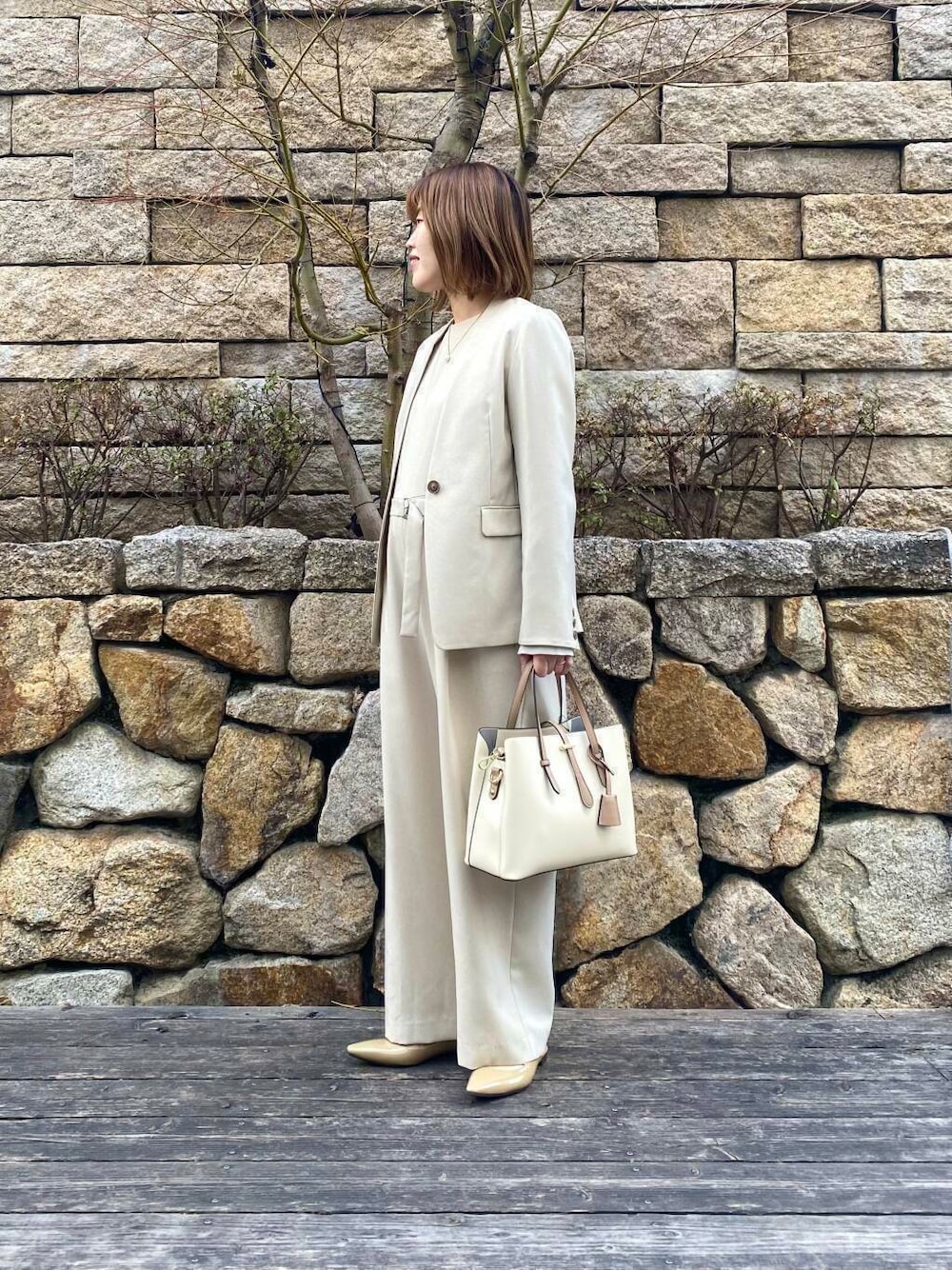 ホワイト系のトートバッグ、ベージュ系のサロペット/オーバーオール、ベージュ系のノーカラージャケットを着用したレディースの春コーディネートの5枚目の写真