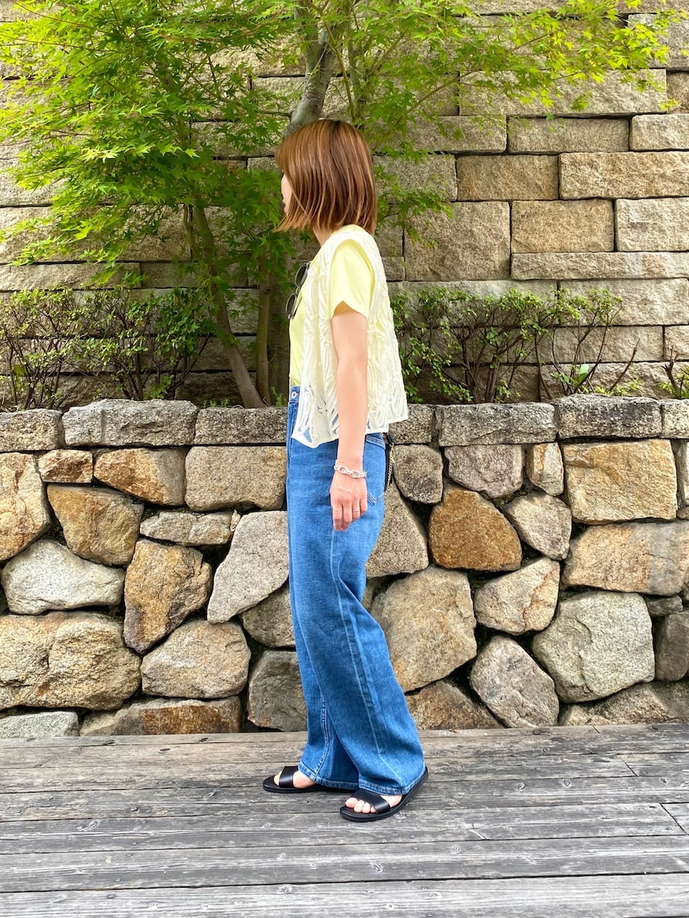 ブラック系のサンダル、ブラック系のショルダーバッグ、ホワイト系のシャツ/ブラウスを着用したレディースの夏コーディネートの3枚目の写真