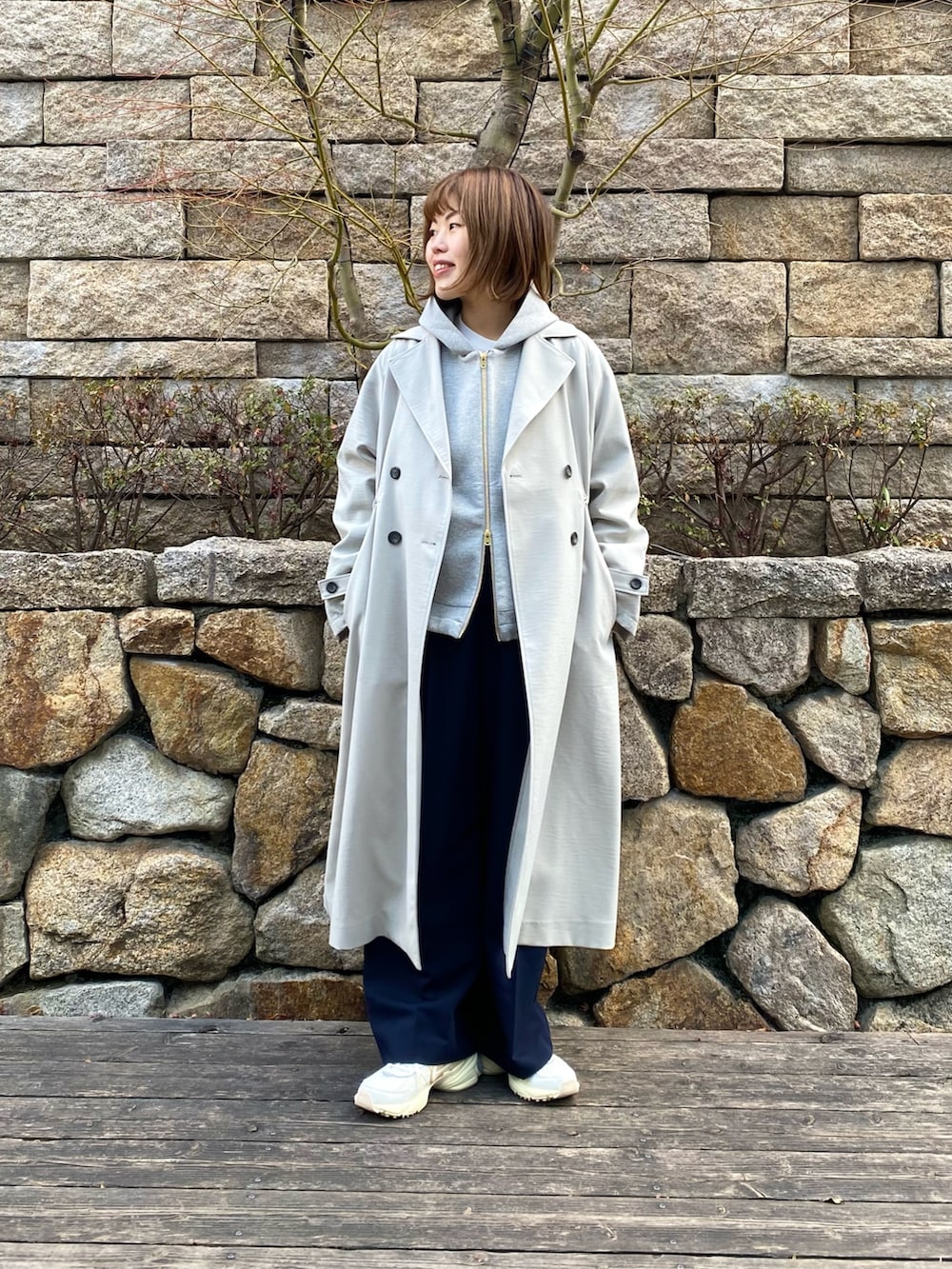 グレー系のブルゾン、ブルー系のサロペット/オーバーオール、ホワイト系のスニーカーを着用したレディースの冬コーディネートの2枚目の写真