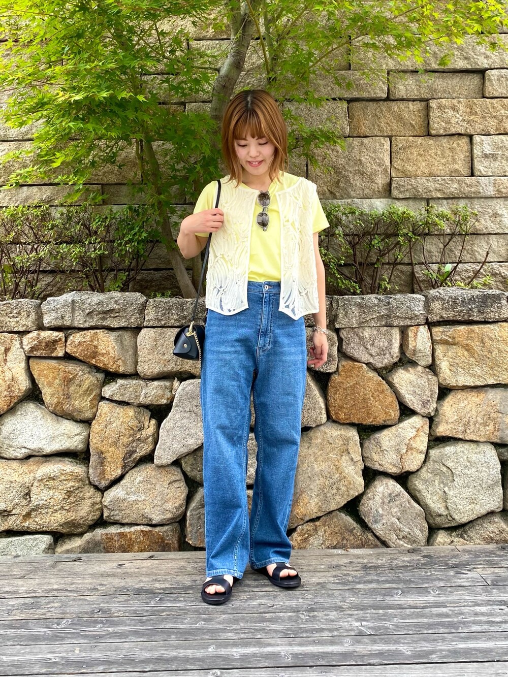 ブラック系のサンダル、ブラック系のショルダーバッグ、ホワイト系のシャツ/ブラウスを着用したレディースの夏コーディネートの5枚目の写真