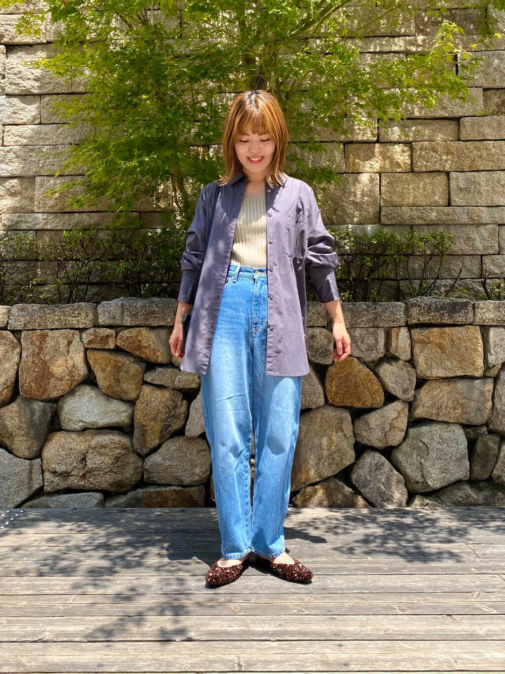 ブラック系のショルダーバッグ、ブルー系のデニムパンツ、ブラウン系のその他シューズを着用したレディースの夏コーディネートの3枚目の写真