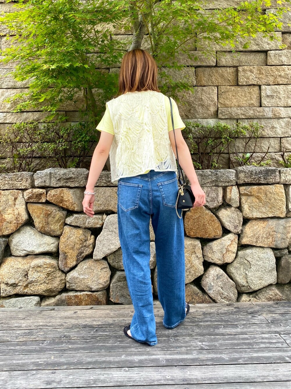 ブラック系のサンダル、ブラック系のショルダーバッグ、ホワイト系のシャツ/ブラウスを着用したレディースの夏コーディネートの4枚目の写真