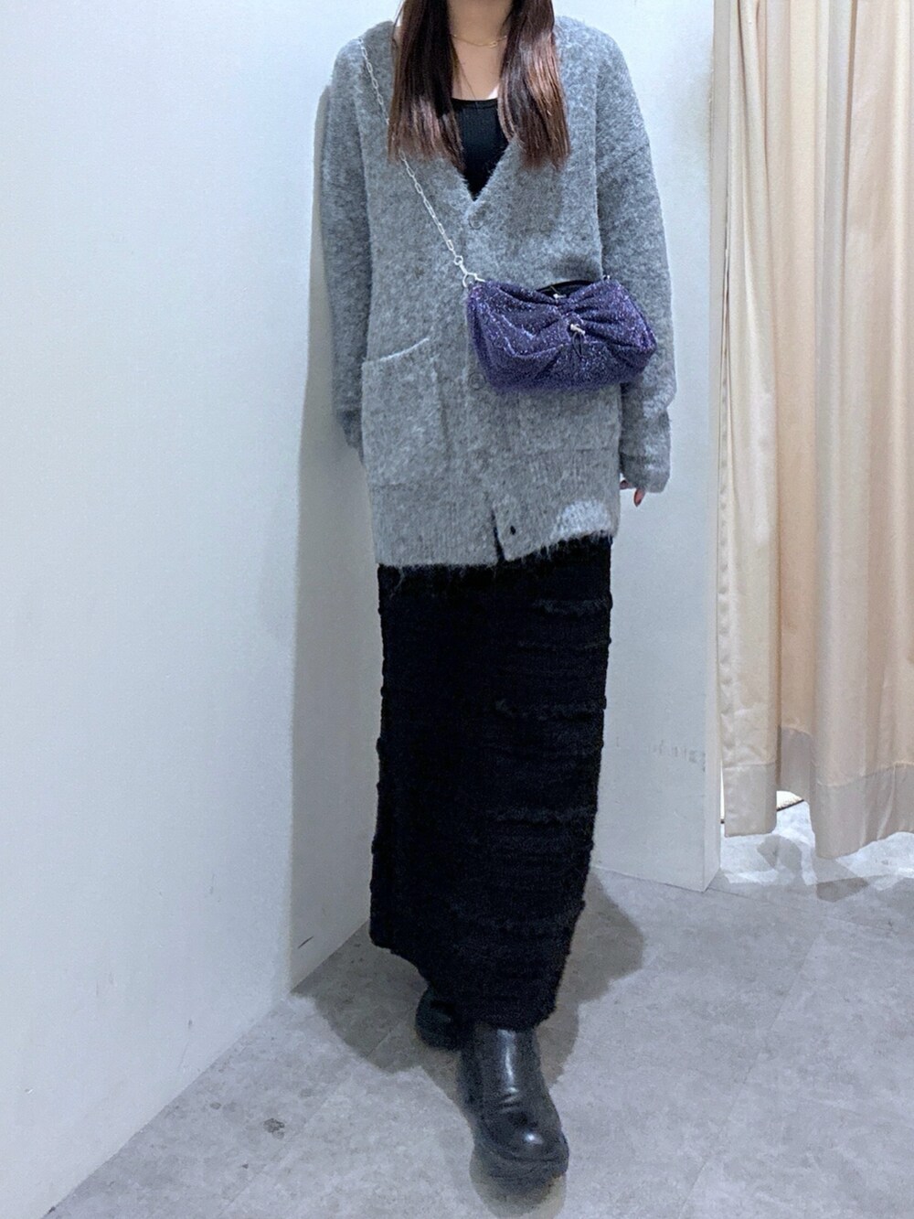グレー系のカーディガン/ボレロ、ブラック系のスカート、シルバー系のハンドバッグを着用したレディースの秋コーディネートの5枚目の写真